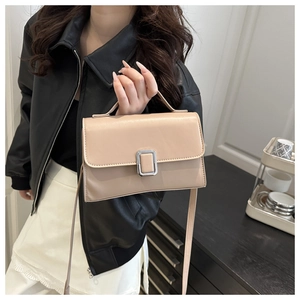 Détail du sac à main beige rectangulaire avec fermoir argenté élégant et texture cuir