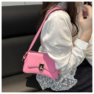 Detailed side view of a pink PU leather underarm bag with golden twist lock on a model