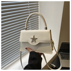 Détail du sac bandoulière blanc cassé avec boucle étoile étincelante et poignée épaisse