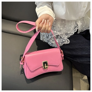 Close-up of pink shoulder bag with gold rectangular metal lock and smooth leather texture