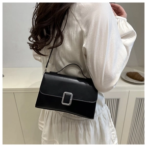 Sac à bandoulière chic en cuir PU noir porté par un mannequin dans un salon