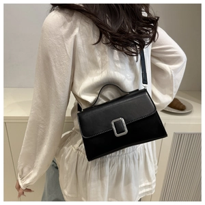 Vue portée d'un sac en cuir noir minimaliste avec boucle argentée et bandoulière fine