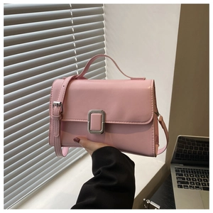 Detail of light pink leather handbag with square silver buckle and adjustable strap