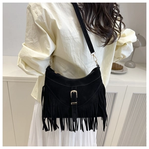 Detail of black suede crescent bag featuring dense fringe tassels and retro metal buckle