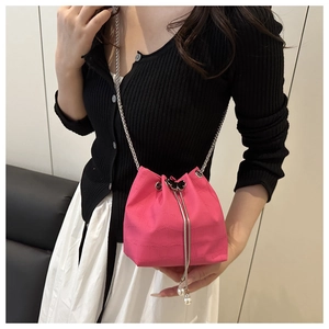 Détail du sac seau rose fuchsia avec texture croco, fermoir papillon et chaîne argent