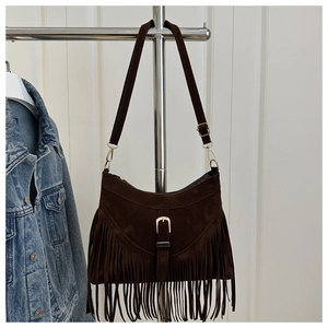 Close-up of vintage brown suede crossbody bag featuring long fringes and gold hardware