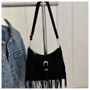 Detail of black suede fringe crossbody bag with gold hardware and tassel accents