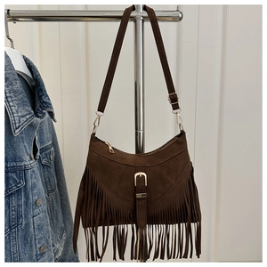 Detail of dark brown fringe crossbody bag with matte finish and gold buckle hardware