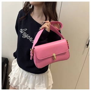 Detailed close-up of a pink leather shoulder bag with a polished gold oval metal clasp