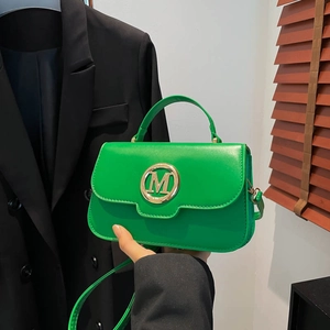 Fashionable bright green leather crossbody bag with gold M buckle and top handle