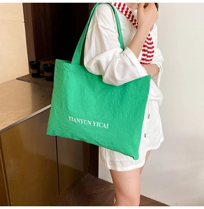 Détail du cabas vert clair avec le logo TIANYUN YICAI et tissu en toile texturée