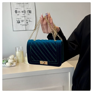 Détail du sac matelassé en velours vert foncé avec bandoulière chaîne et fermoir doré