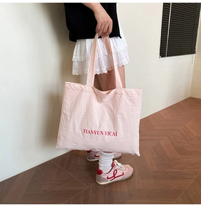 Détail du grand sac cabas rose en toile avec inscription TIANYUN YICAI en rouge vif