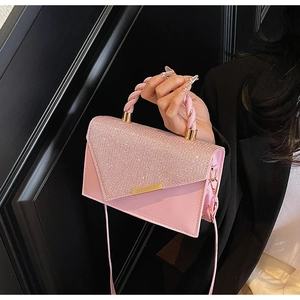 Detail of pink crossbody bag with sparkling rhinestones and a braided handle