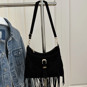 Fashionable black faux suede half-moon shoulder bag with fringe and gold metal buckle