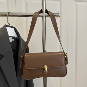 Retro brown leather underarm bag for women with a gold cylindrical buckle closure