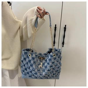 Détail du sac en denim à damier avec franges et pendentif en forme de cerf doré