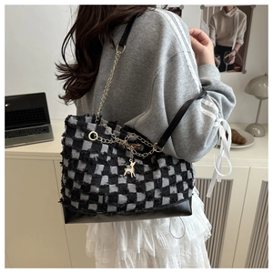 Gros plan du sac en denim à damier avec chaîne dorée et élégant pendentif cerf