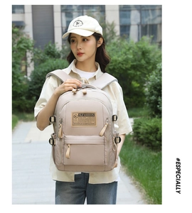 Donna con zaino beige impermeabile con etichetta SLFASHION in un ambiente urbano
