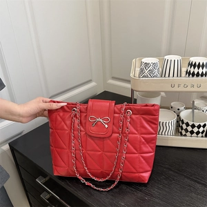 Red quilted tote bag with silver bow accent and leather woven chain strap for women