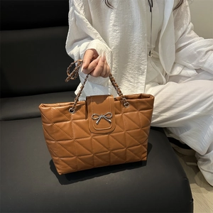 Brown quilted tote bag with silver bow buckle and chain handle for daily commute