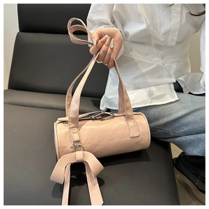 Detailed view of pink barrel bag with soft leather finish and large decorative bow