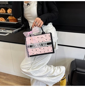 Detailed view of pink quilted tote with black bow prints and silk ribbon decoration