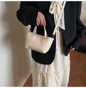 Detailed close-up of cream lychee texture leather mini bucket bag with slender strap