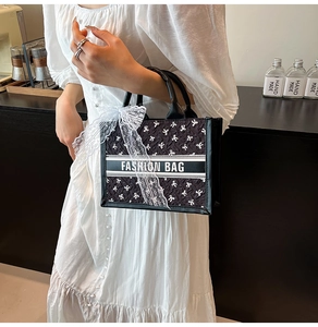 Fashion tote bag with silk scarf detail and large bow accessory in a stylish room setting