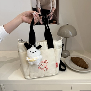 Fashionable beige canvas tote bag with cute cartoon bear print and plush pendant accessory