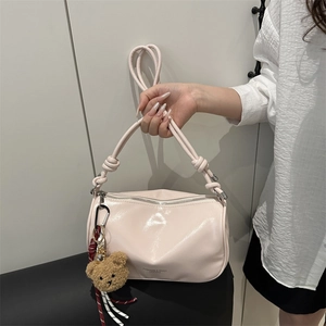 Pink cylinder handbag with patent leather texture and a cute plush bear charm