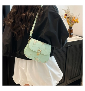 Détail du sac bandoulière vert menthe avec broderie florale délicate et fermoir doré