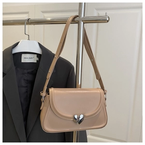 Detail der beigen Leder-Satteltasche mit einer silbernen Schnalle in rissiger Herzform