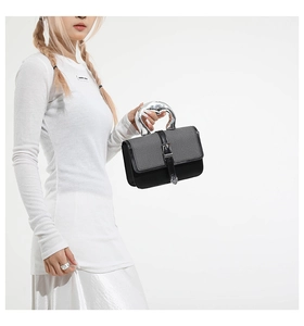 Detail of the unique silver liquid metal handle on a two-tone fabric and leather handbag