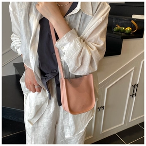 Close-up of pink litchi grain leather bucket bag with elegant shoulder strap detail