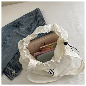 Top view of white drawstring tote bag showing spacious interior with notebooks and books