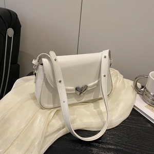 Minimalistische weiße Umhängetasche mit Herzschnalle auf elegantem Stoffhintergrund