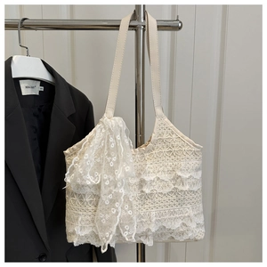 Detailed macro view of delicate cream lace layers and large bow on beach tote bag