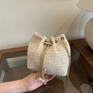 Woven bucket bag with gold chain strap and pearl charms, summer fashion crossbody style