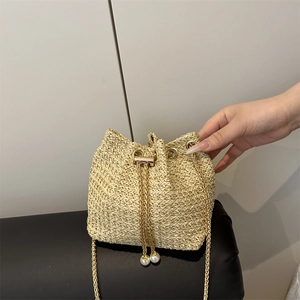 Chic woven straw bucket bag with pearl drawstring and gold chain strap for summer fashion