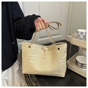 Détail du sac cabas en paille avec chaîne dorée et breloque cerf en beige