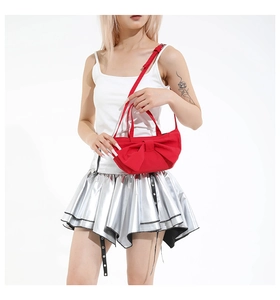 Détail d'un sac à main noeud rouge en nylon porté par un mannequin en tenue d'été