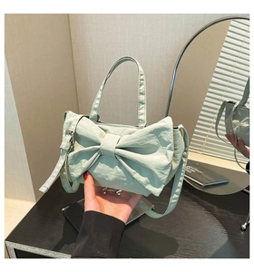 Détail du sac en nylon vert menthe avec design de nœud et texture de tissu plissée