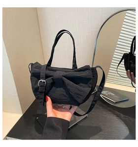 Détail du sac en nylon plissé noir avec grand nœud et bandoulière réglable