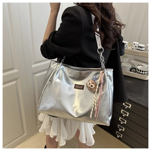 Silver metallic tote bag with chain strap and cute plush monkey charm for women