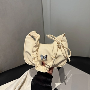 Elegant beige pleated shoulder bag with silver butterfly charm and soft fabric texture