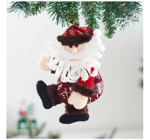 Detailed plush Santa ornament with sequins hanging on a green Christmas tree branch