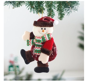 Detail of plush snowman ornament with red hat and scarf hanging on Christmas tree branch