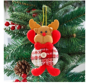 Close-up of a plush reindeer ornament with red bow on a Christmas tree branch