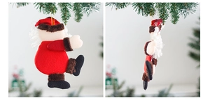 Detail of Santa Claus ornament hanging on a Christmas tree with golden string